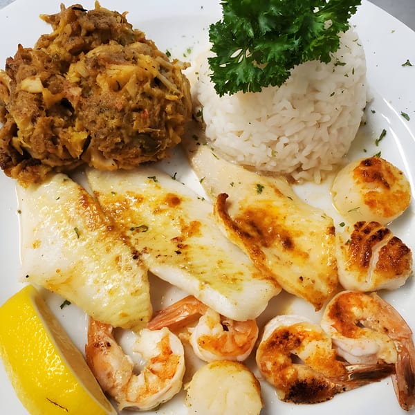Quickway Diner's seafood platter with fish, shrimp, scallops, rice, crab stuffing, and a lemon wedge.