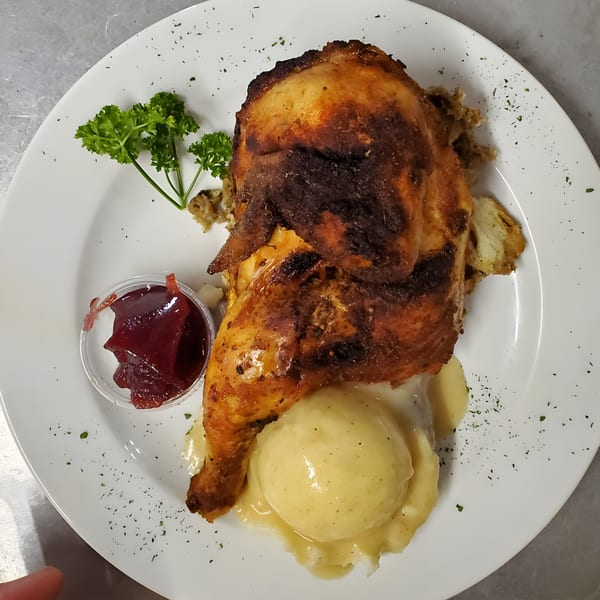 Quickway Diner's roasted chicken with mashed potatoes, gravy, stuffing, cranberry sauce, and parsley.
