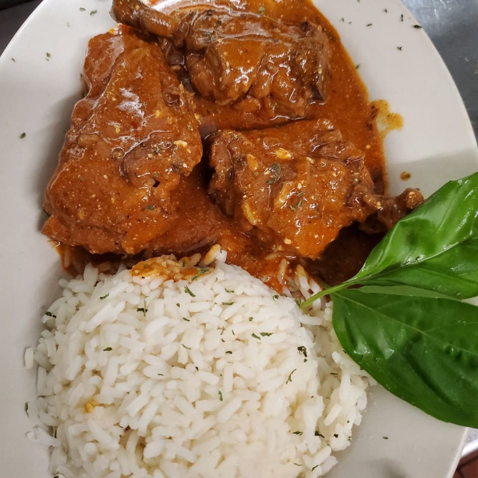 Quickway Diner's chicken in a rich brown sauce with white rice and fresh basil.